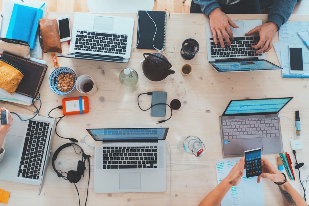 Laptops and mobile technology around a conference room table.